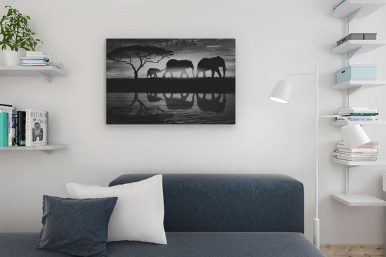 Tableau de famille d'éléphants en noir et blanc avec reflet, au-dessus d'un canapé dans un salon minimaliste.