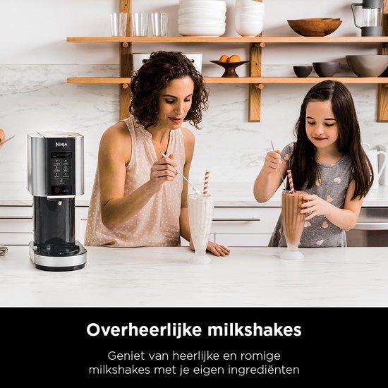 Moeder en dochter genieten van milkshakes in een keuken, met de Ninja ijsmachine op de achtergrond.