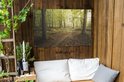 Tuinposter met boszicht, een pad slingert door het bos, omringd door bomen met fris groen blad.