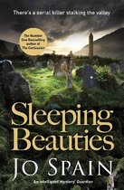 Boekomslag van 'Sleeping Beauties' door Jo Spain met een griezelige kerkhofscène bij zonsondergang. 'There's a serial killer stalking the valley.'