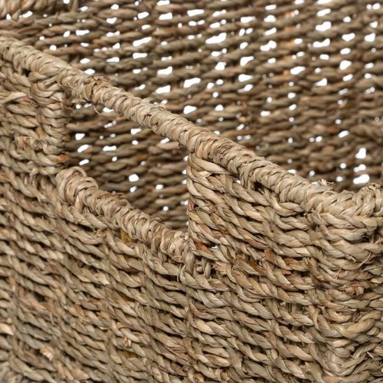 Detailopname van de textuur van een gevlochten mand van zeegras met een handvat.