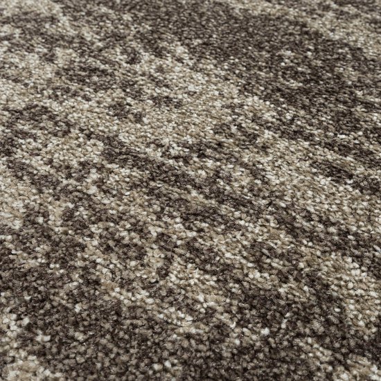 Een close-up van de textuur van een bruin vloerkleed met willekeurige beige spikkels.