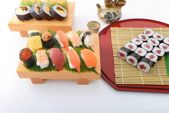 Een verscheidenheid aan sushi en maki, geserveerd op houten schalen en een rode dienblad met bamboe sushi mat.
