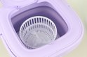 Paarse mini-wasmachine met open deksel, tonen de binnenkant met een witte centrifuge.