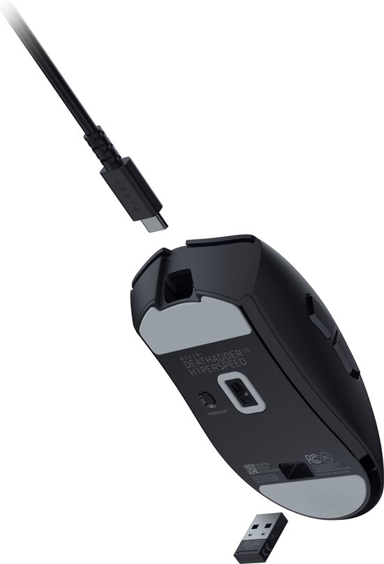 De onderkant van een zwarte Razer DeathAdder V3 Hyperspeed muis met een USB-C poort en USB-dongle.