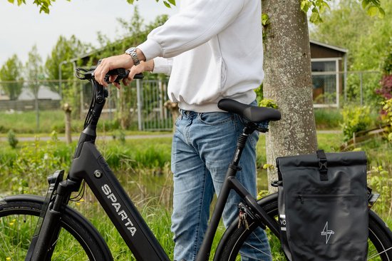 Zwarte Sparta e-bike met een man in spijkerbroek en witte hoodie, met zwarte zadeltas.