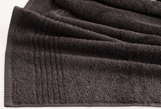 Serviette gris anthracite pliée avec un motif côtelé sur le bord.