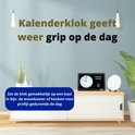 Oudere persoon plaatst een OER dementieklok op een kast, met de tekst 'Kalenderklok geeft weer grip op de dag'.