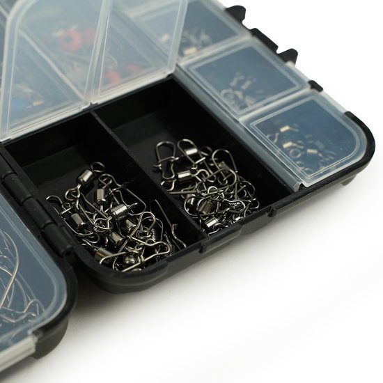 Close-up van een open tacklebox met vakjes gevuld met metalen visartikelen zoals wartels.