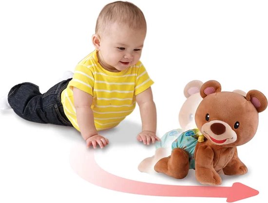 Baby in geel-wit gestreept shirt en spijkerbroek kruipt achter een bewegende bruine beer aan.