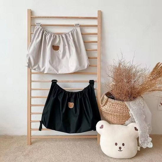 Twee hangende organizers aan een houten rek: een lichtkleurige en een zwarte, beide met teddybeerlogo.