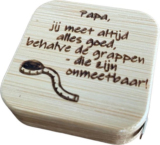 Houten rolmaat met de tekst 'Papa, jij meet altijd alles goed, behalve dé grappen - die zijn onmeetbaar!' en een tekening van een rolmaat.