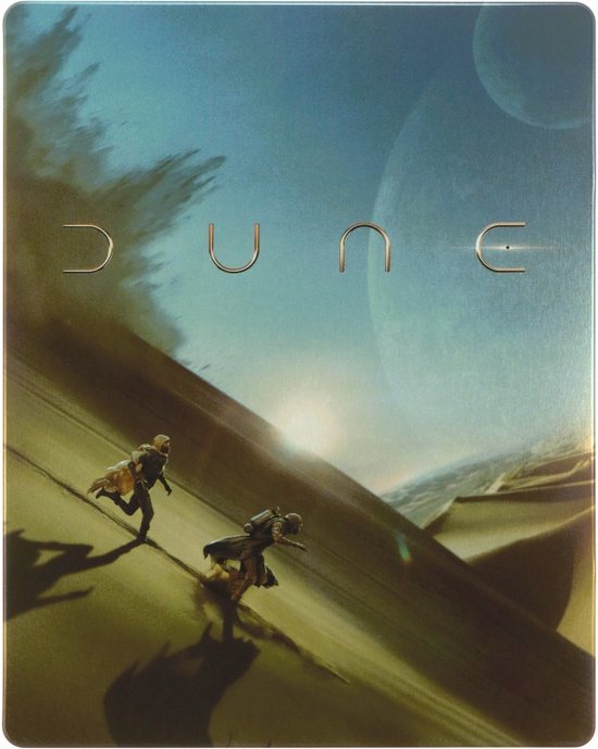 Stalen hoes van de film "Dune" met twee figuren op een zandduin onder een blauwe hemel met planeten.