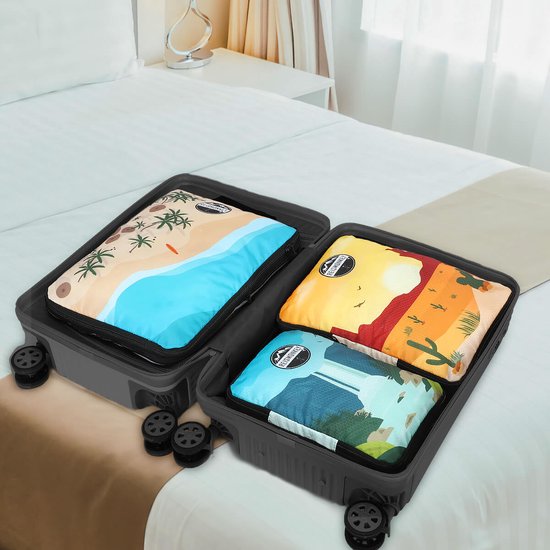 Drie packing cubes met verschillende prints (strand, woestijn, waterval) georganiseerd in een open koffer.