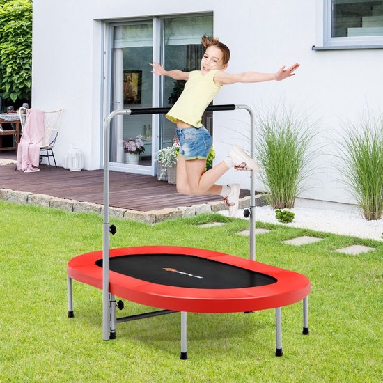 Jongen springt op een rode trampoline met grijze handgreep in een tuin.