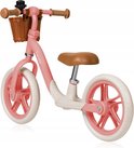 Een roze loopfiets met bruin zadel, rotan mandje, witte banden en roze velgen.