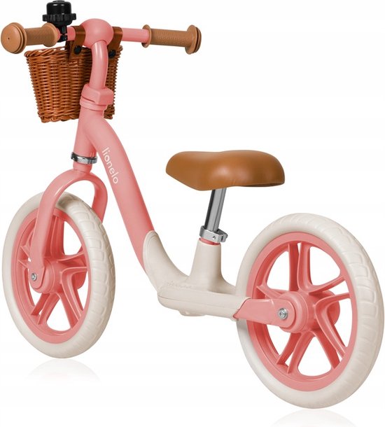 Een roze loopfiets met bruin zadel, rotan mandje, witte banden en roze velgen.