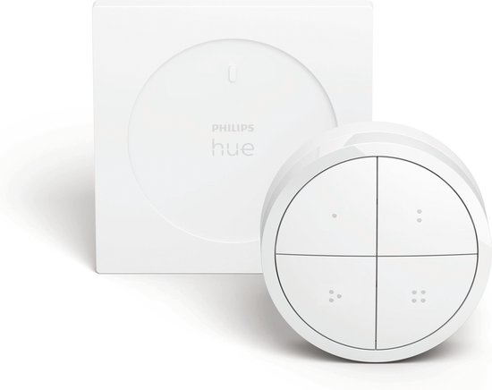 Een witte Philips Hue Tap Dial Switch met zijn witte houder. De ronde schakelaar heeft vier knoppen, elk met twee kleine puntjes.