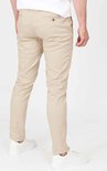 Achterkant van een mannen chino in lichtbeige, gedragen met witte sneakers.
