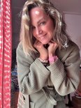 Vrouw in olijfgroene wafel badjas, met riem om en handen bij de nek.