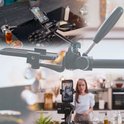 Close-up van statief met smartphone in keukenopstelling, vrouw filmt in keuken.