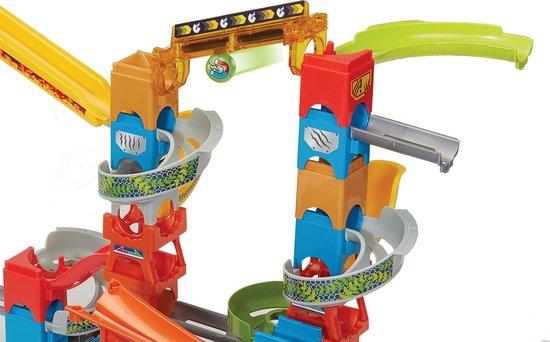 Gedetailleerd deel van een kleurrijke knikkerbaan met rode, blauwe en oranje torens en gele hellingen.