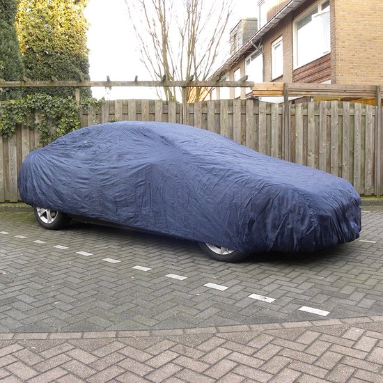 Donkerblauwe autohoes op een oprit, beschermt een sedan.