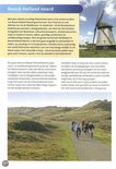 Fietsers op een pad met op de achtergrond duinen en een molen.