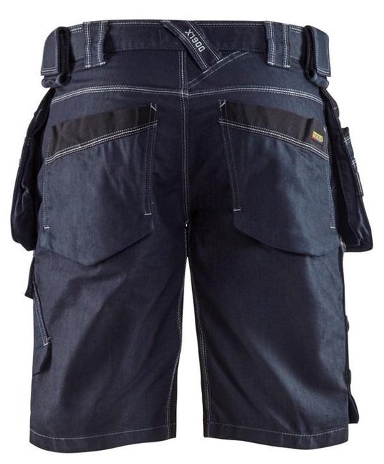 Achterkant van een donkerblauwe werkshort met label 'X1900', riemlussen, zakken en witte stiksels.