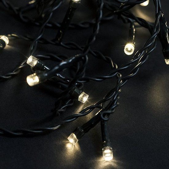 Detailopname van donkergroene kerstverlichting met warm witte LEDlampjes.
