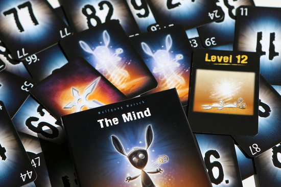 Spel 'The Mind' met kaarten, waaronder 'Level 12', cijferkaarten en een doos.
