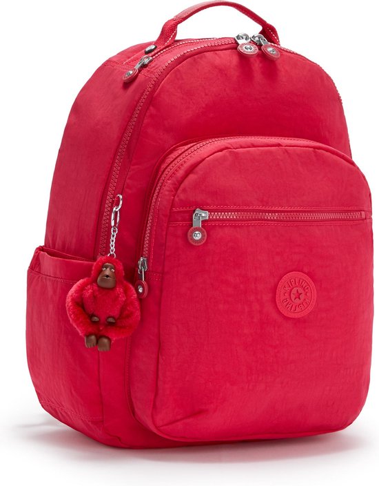 Sac à dos Kipling rouge avec porte-clés singe rouge, une poche avant zippée et des poches latérales.