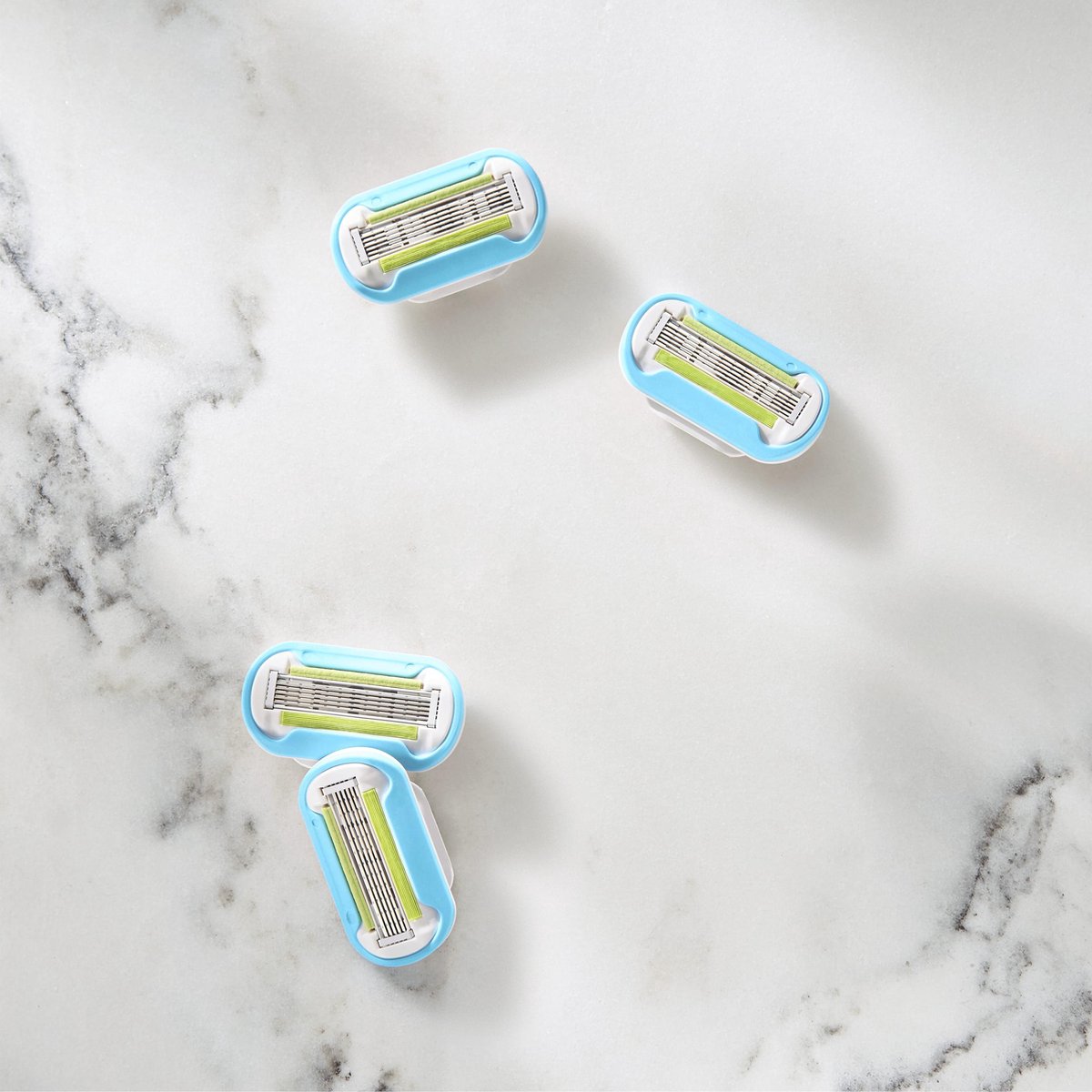 Verpakking met 4 Gillette Venus Extra Smooth navulmesjes, blauw en groen.