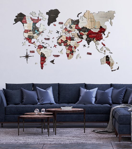 Grande carte du monde 3D en bois accrochée au mur au-dessus d'un canapé d'angle bleu foncé.