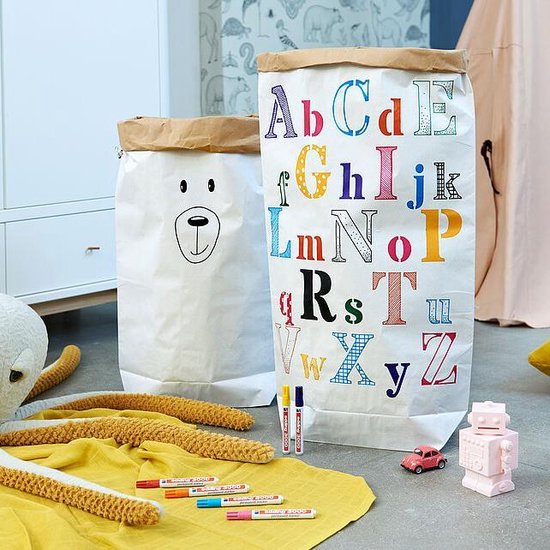 Twee grote papieren zakken in een kinderkamer, één met een beertje, de ander met het alfabet.