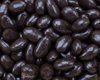 Een close-up van pure chocolade hazelnoten. De noten zijn donkerbruin, glanzend en ovaalvormig.