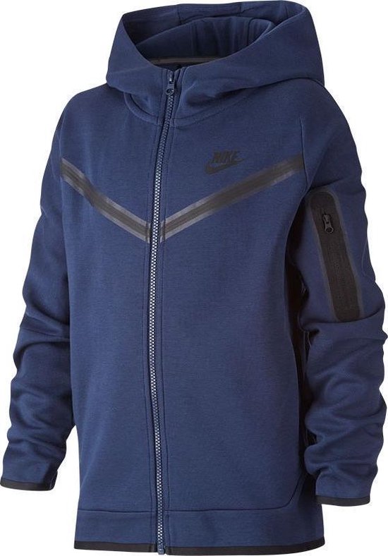 Jongen draagt een donkerblauw Nike Tech Fleece vest met capuchon.