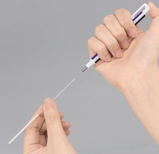 Hand houdt een Tombow Mono Zero gum vast, zwarte dop zichtbaar. Een nieuwe gumstift wordt eruit getrokken.