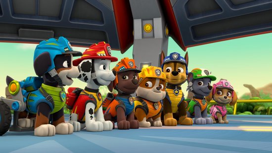 Zeven pups staan op een rij, sommigen met helmen en in uniformen, klaar voor actie.