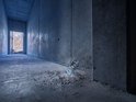 Bosch laser afstandmeter valt op de grond in een betonnen gang. Het apparaat stuift stof op.