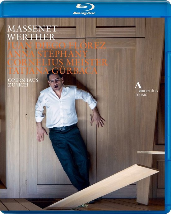 Blu-ray hoes van Massenet Werther met Juan Diego Flórez in wit overhemd en zwarte broek, leunend tegen een houten kast.