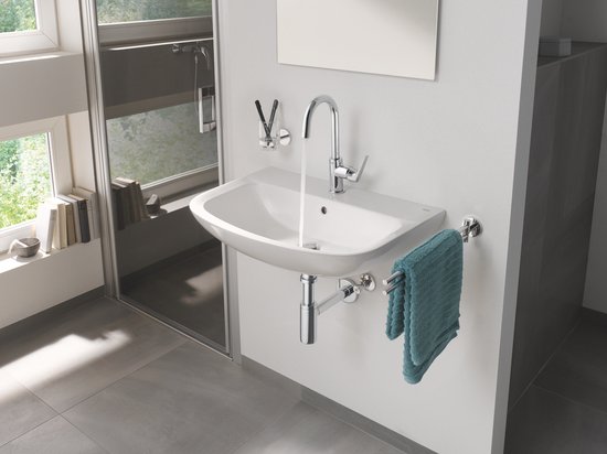 Een chroom GROHE wastafelkraan met gebogen uitloop boven een witte wastafel.
