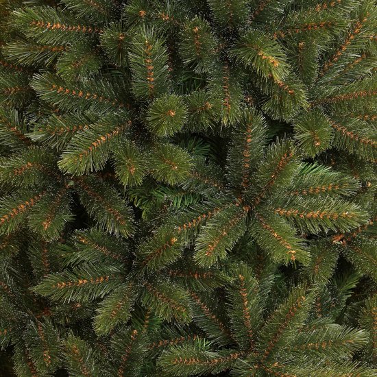 Dicht op elkaar staande groene kerstboomtakken met bruine accenten.