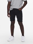 Man met gestreept t-shirt en zwarte denim shorts, witte sneakers.
