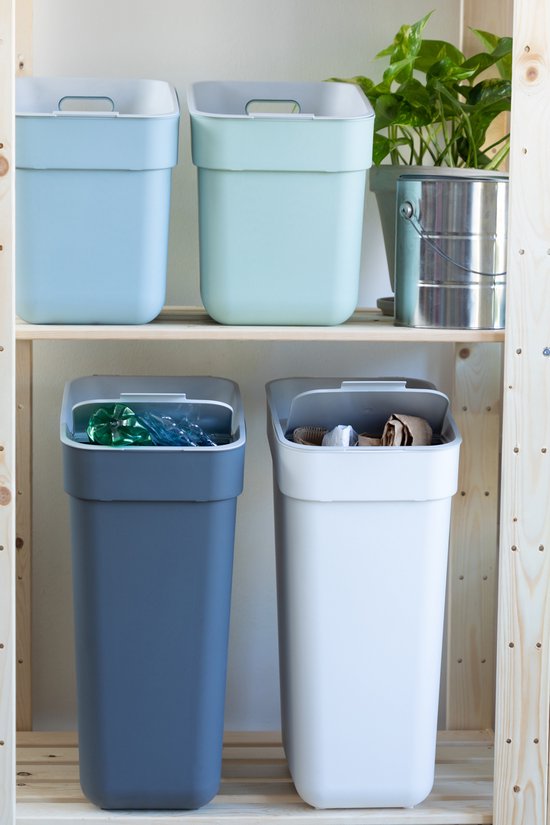 Une poubelle gris foncé et une blanche avec couvercles, sur une étagère en bois. Au-dessus se trouvent des poubelles bleu clair et vert clair.
