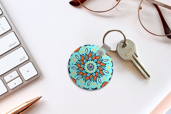 Porte-clés - motif sur fond bleu clair avec une fleur orange et des décorations - Plastique - Rond