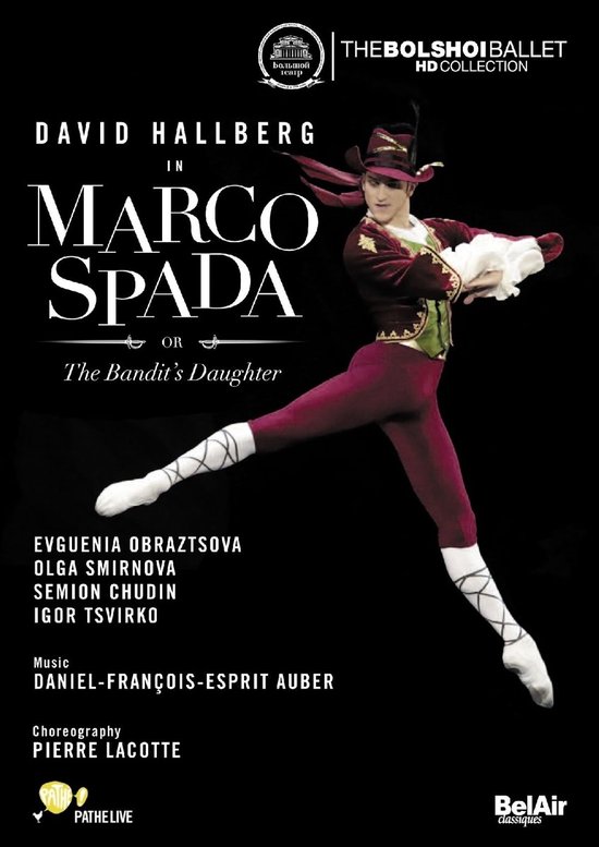 David Hallberg als Marco Spada, gekleed in een bordeauxrode outfit met hoed en witte sokken, in een pose.