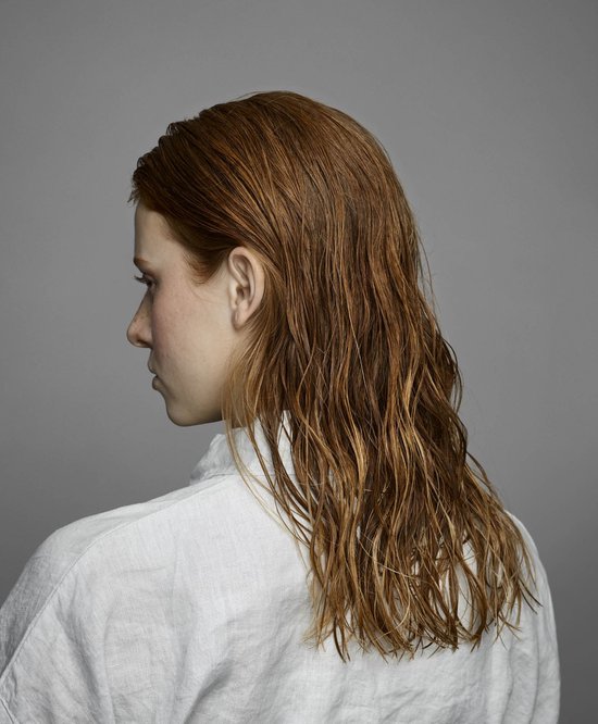 Model van achteren gezien, met lang, roodbruin, nat haar.