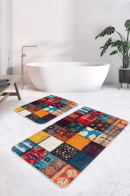 Twee patchwork badmatten met levendige kleuren en patronen, geplaatst op een lichte tegelvloer naast een wit bad.