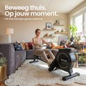 Vrouw traint op een zwarte roeitrainer in een woonkamer, met tekst over calorieverbranding.